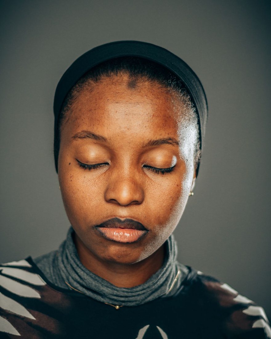 A Black woman resting with her eyes closed, at peace — a moment of being fully understood